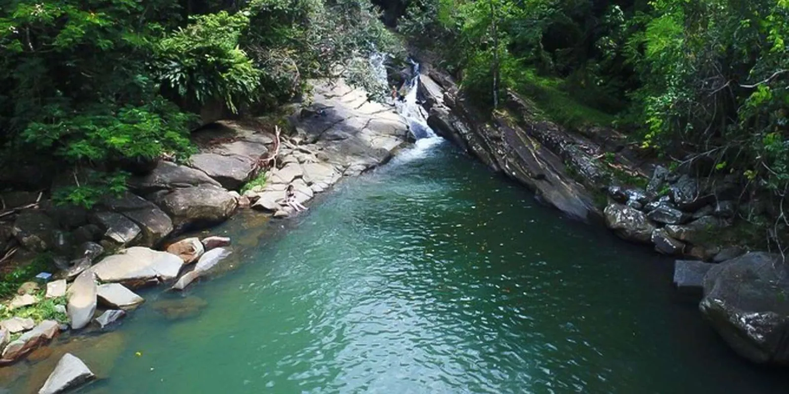 The deep green collecting pool at the foot of the waterfall, empty of crowds