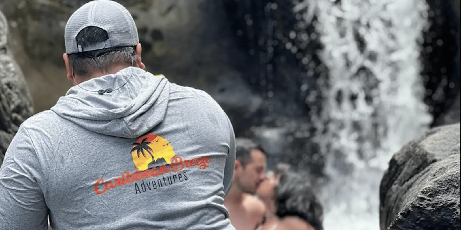 A guide watching the group from the rocks beside the waterfall