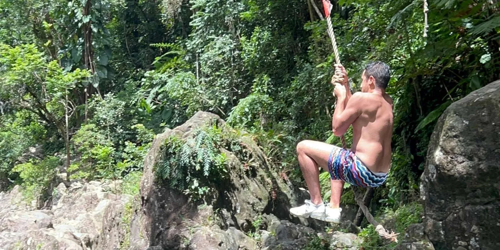 A guest swinging out over the water on the rope swing