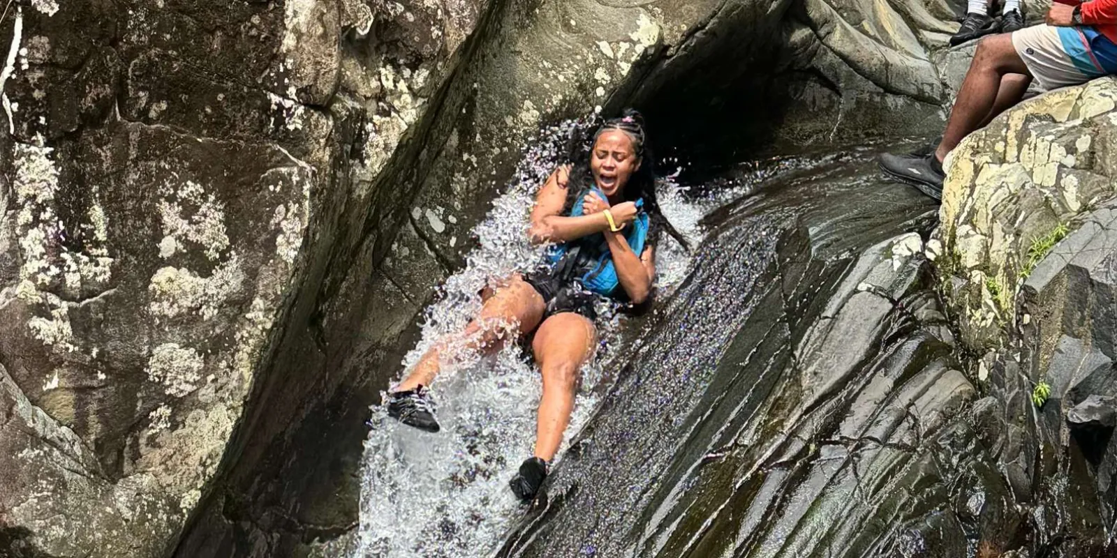 A guest riding the natural waterslide down the rock chute